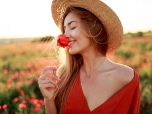 mulher-loira-romantica-com-flor-na-mao-caminhando-no-campo-de-papoulas-incrivel-cores-quentes-do-sol-chapeu-de-palha-vestido-vermelho-cores-suaves_273443-2841